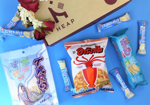 Heap brand box with blue Thai snacks and flower garland